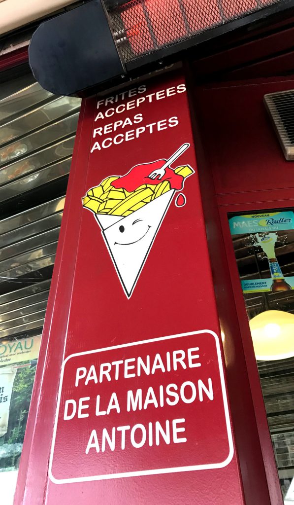 Dette skilt giver dig adgang til at købe drikkevarer og spise dine fritter fra Maison Antoine